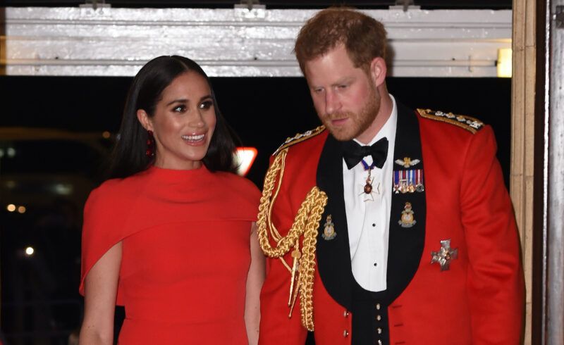 El príncipe Harry y Meghan Markle con atuendos rojos