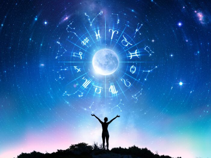 Person med utstrakte armer som ser på en stjernehimmel med stjernetegnene rundt en måne.