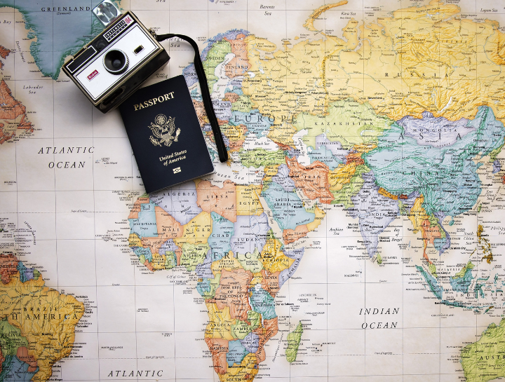 Et pass og retrokamera på toppen av et verdenskart.