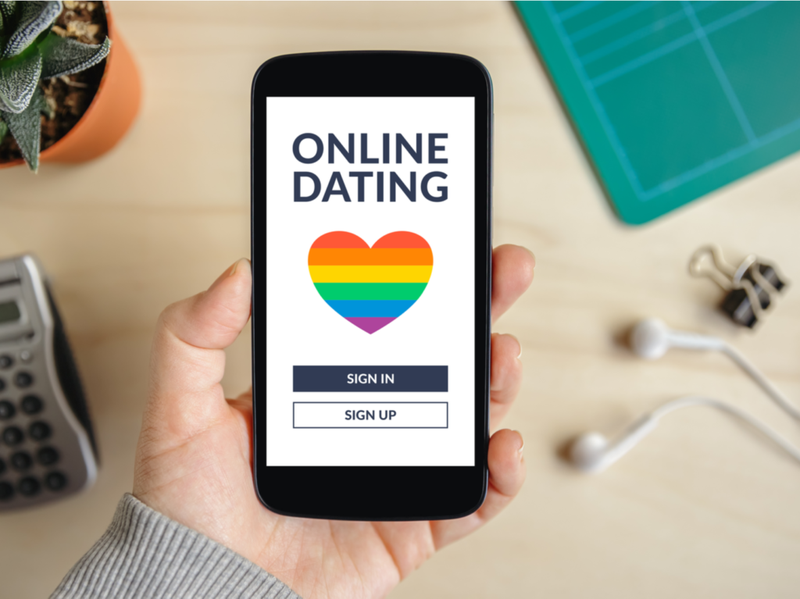 Hånd som holder smarttelefon med LHBT dating app-konsept på skjermen. Gay online dating. Topp utsikt
