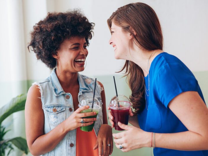 स्मूदी पीते हुए बातचीत करती दो महिलाओं की छवि।