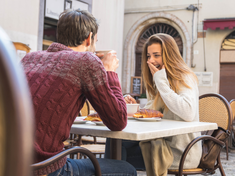 Ungt par snakker på kaffebaren på en date. Kjære par som har det gøy på en restaurant.