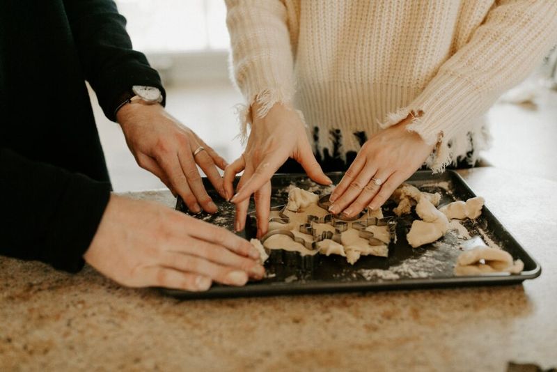 Imagen de un hombre y una mujer horneando galletas juntos.
