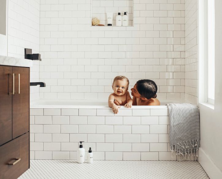naine ja beebi avalike kaupade toodetega vannis